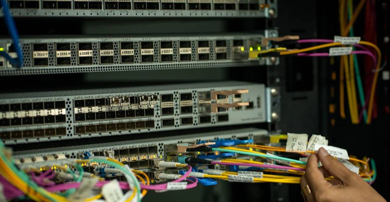 Manos trabajando sobre el rack de fibra